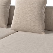 Nahaufnahme eines Lounge-Sets mit beigen Kissen und Textilbezug, Perspektive von vorne.