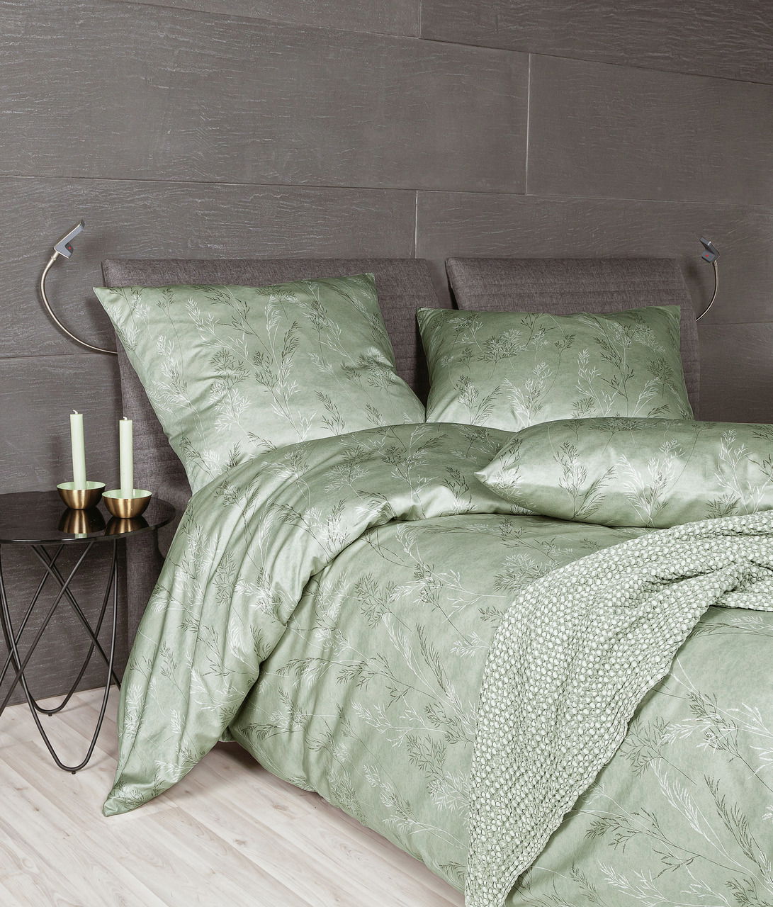 Grünes Mako-Satin Bettwäsche-Set mit floralem Muster auf einem Bett, seitliche Perspektive