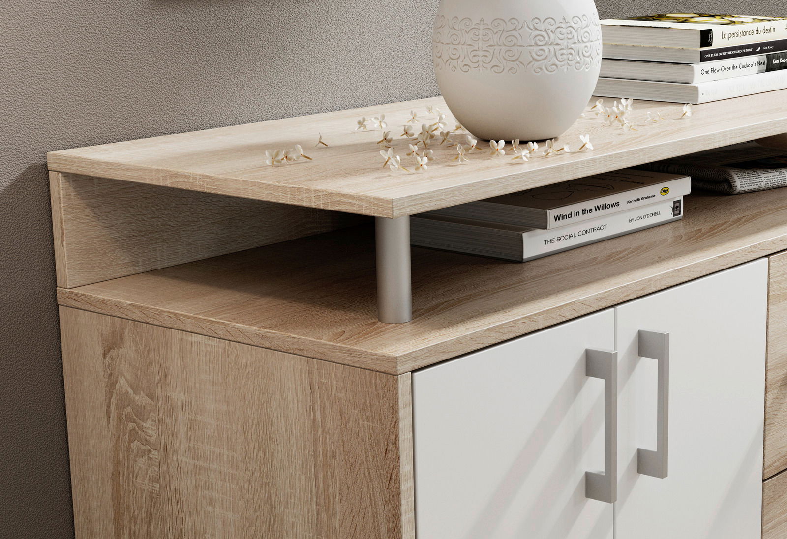 Nahaufnahme eines modernen Sideboards mit Holzoptik und weißen Türen, dekoriert mit Büchern und einer Vase, aus seitlicher Perspektive.