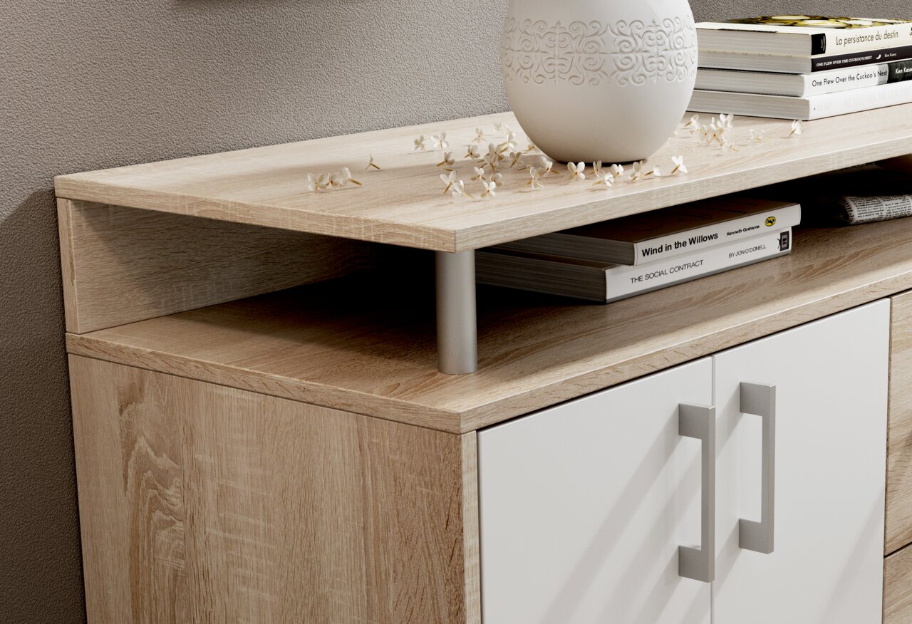 Nahaufnahme eines modernen Sideboards mit Holzoptik und weißen Türen, dekoriert mit Büchern und einer Vase, aus seitlicher Perspektive.