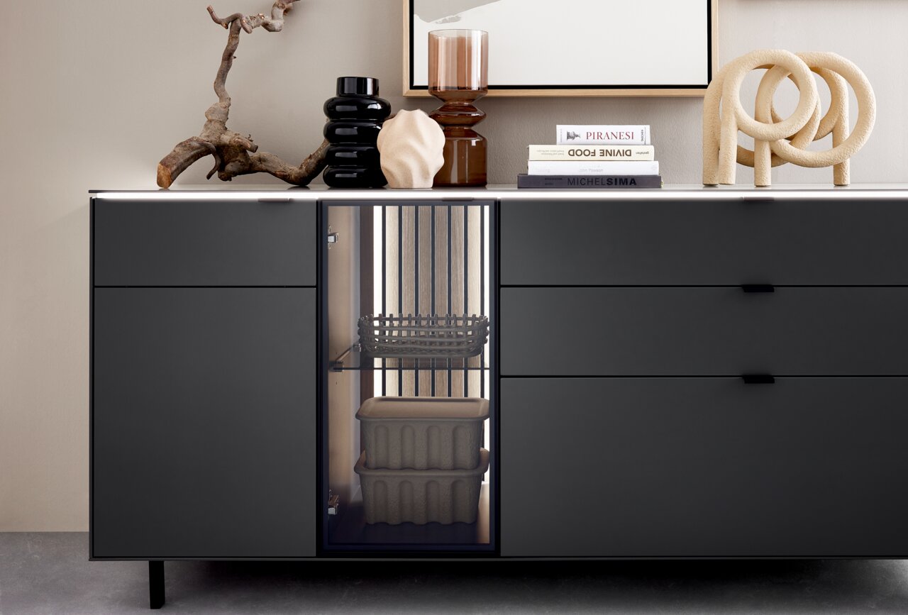 Modernes Sideboard in dunklem Design mit dekorativen Objekten auf der Oberseite, seitliche Perspektive