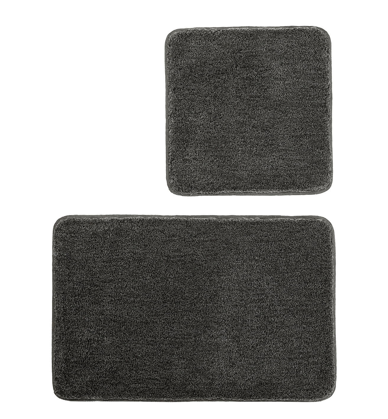 Zweiteiliges Badteppich-Set in Dunkelgrau, bestehend aus einem großen rechteckigen und einem kleineren quadratischen Teppich, aus der Vogelperspektive fotografiert.