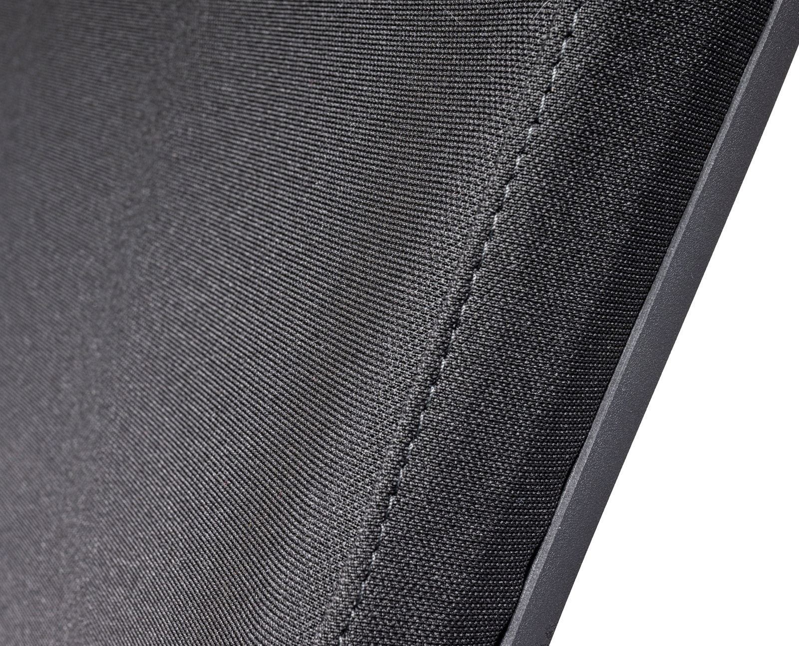 Nahaufnahme der Textur eines Chefsessels aus schwarzem Stoff, seitliche Perspektive