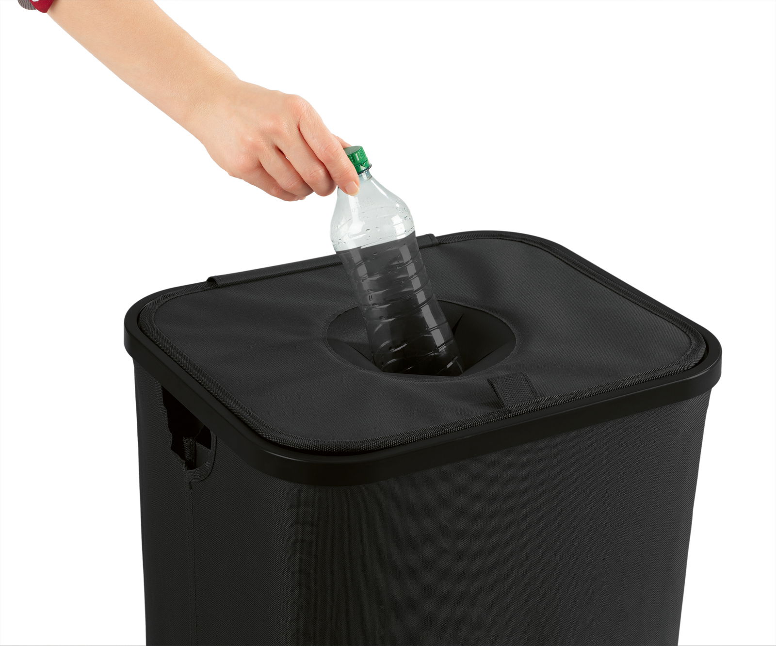 Eine Hand wirft eine Plastikflasche in einen schwarzen Pfandflaschen Sammelbehälter. Perspektive von oben.