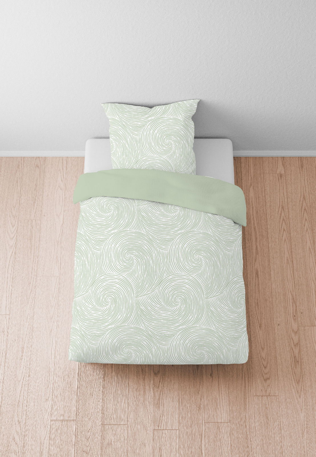 Bettwäsche-Set in hellem Grün mit spiralförmigem Muster, auf einem Bett von oben fotografiert.