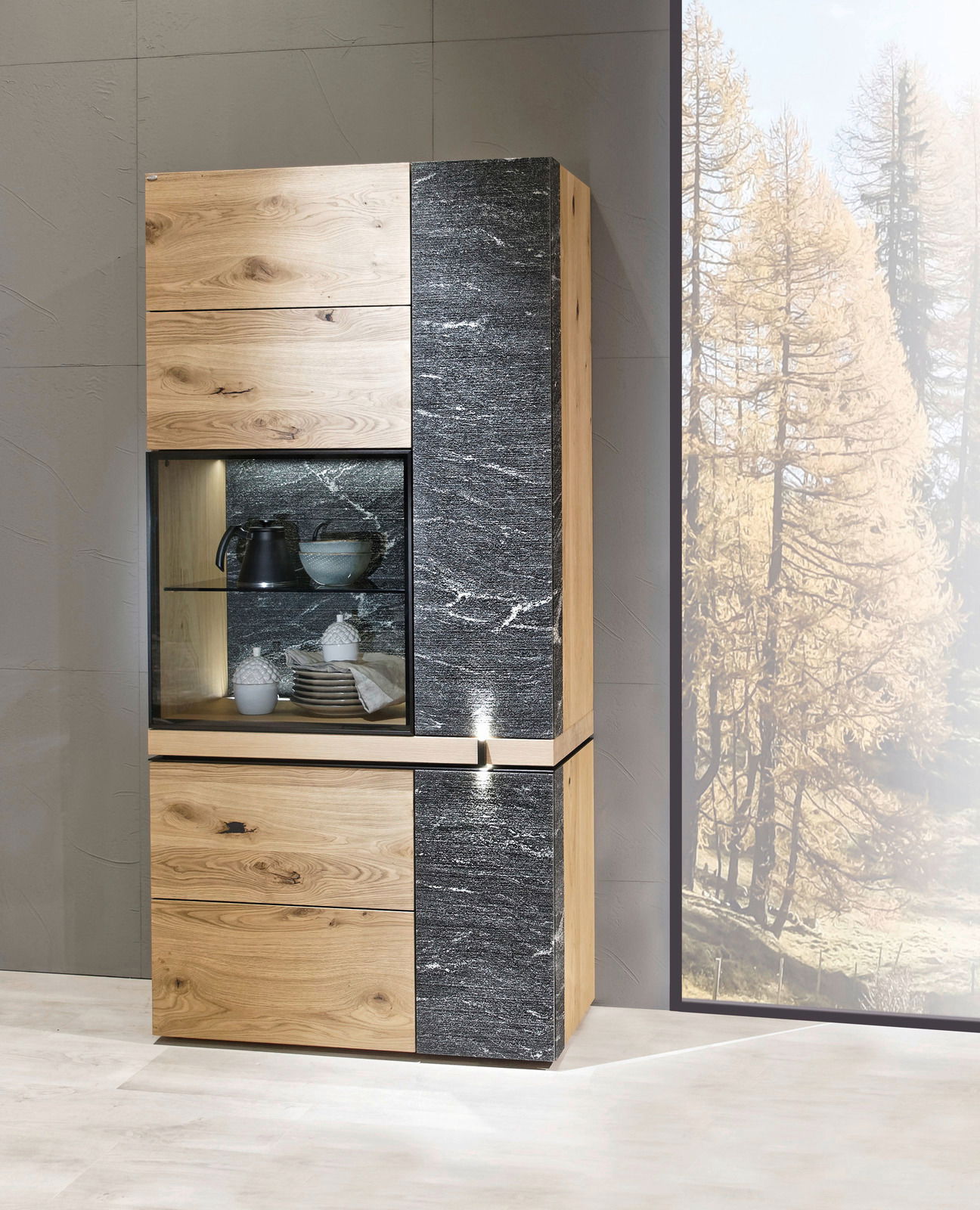 Moderne Vitrine aus Holz und Steinoptik, frontal fotografiert, mit Glaseinsatz und dekorativen Gegenständen.