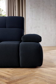 Nahaufnahme einer modernen, dunkelgrauen Eckgarnitur mit strukturiertem Stoffbezug, seitliche Perspektive