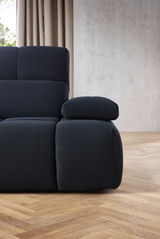 Nahaufnahme einer modernen, dunkelgrauen Eckgarnitur mit strukturiertem Stoffbezug, seitliche Perspektive