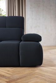 Nahaufnahme einer modernen, dunkelgrauen Eckgarnitur mit strukturiertem Stoffbezug, seitliche Perspektive