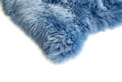 Close-up van een blauwe schapenvacht met een zachte, donzige textuur, gezien vanaf de zijkant.