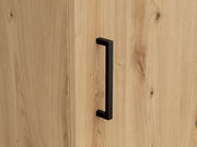 Nahaufnahme einer Holzkommode mit schwarzem Griff, seitliche Perspektive