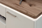 Detailansicht aus schräger Seitenperspektive: weiße Küchenfront mit Metallgriff und Arbeitsplatte in Holzoptik mit abgerundeter Kante