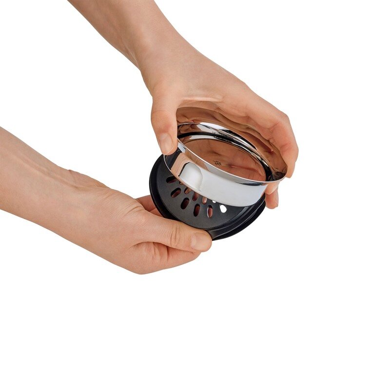 Nahaufnahme eines Deckels für eine Wasserkaraffe, der von zwei Händen gehalten wird.