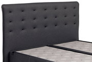Boxspringbett mit grauem, gestepptem Kopfteil, seitliche Perspektive