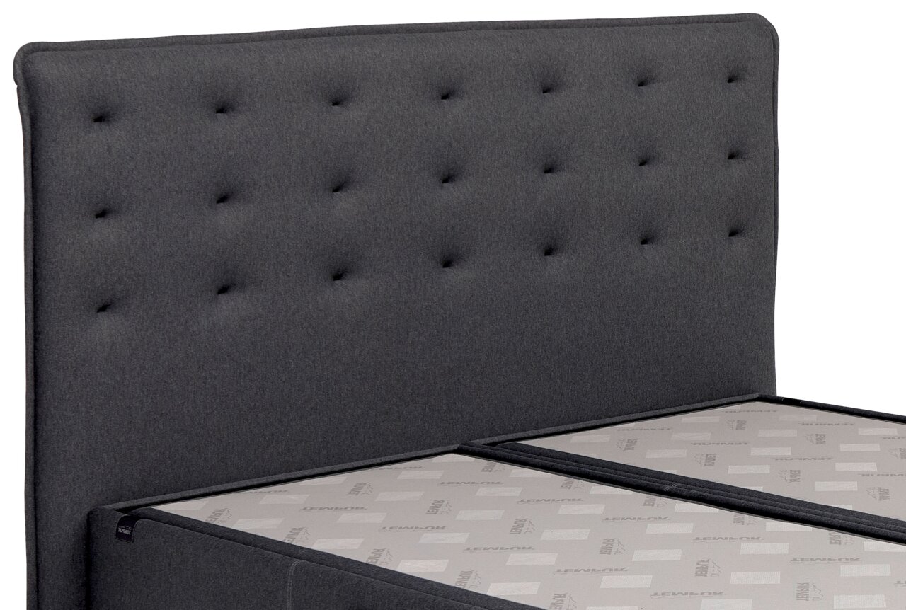 Boxspringbett mit grauem, gestepptem Kopfteil, seitliche Perspektive