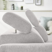 Nahaufnahme einer grauen Eckgarnitur mit verstellbaren Kopfstützen, seitliche Perspektive.