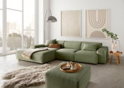 Groene modulaire bank in een moderne woonkamer met grote ramen, twee abstracte kunstwerken aan de muur en een zacht tapijt, gezien vanuit het perspectief linksvoor.