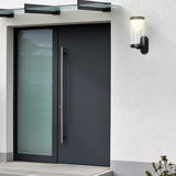 Moderne Akku-Außenwandleuchte an einer Hauswand neben einer Eingangstür, seitliche Perspektive