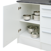 Kücheninsel mit geöffneter Schranktür, die Edelstahlkochtöpfe und -schüsseln auf zwei Regalböden zeigt, Perspektive von vorne.