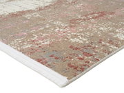 Nahaufnahme eines Designer-Teppichs mit abstraktem Muster in Beige, Rosa und Weiß, perspektivisch von der Seite aufgenommen.
