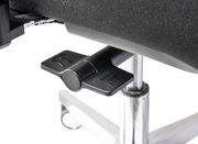 Nahaufnahme eines schwarzen Hebels unter einem Chefsessel, der auf einem verchromten Stuhlbein montiert ist.