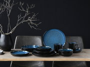 Kombiservice 16-tlg in elegantem Schwarz und Blau, bestehend aus Tellern, Schalen und Tassen, auf einem Tisch arrangiert, seitliche Perspektive.