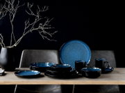 Kombiservice 16-tlg in elegantem Schwarz und Blau, bestehend aus Tellern, Schalen und Tassen, auf einem Tisch arrangiert, seitliche Perspektive.