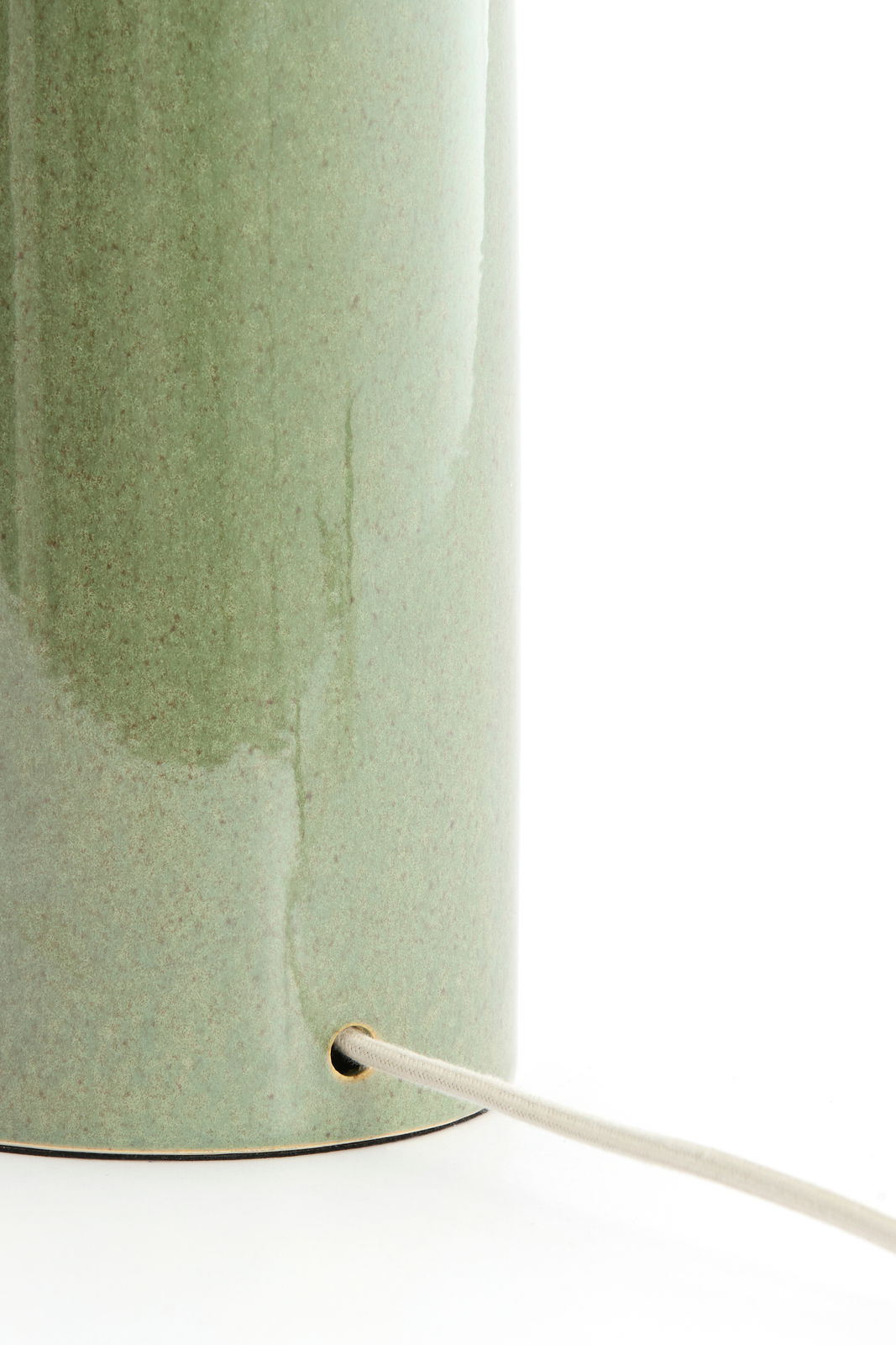 Nahaufnahme eines grünen Lampenfußes mit Kabel, seitliche Perspektive