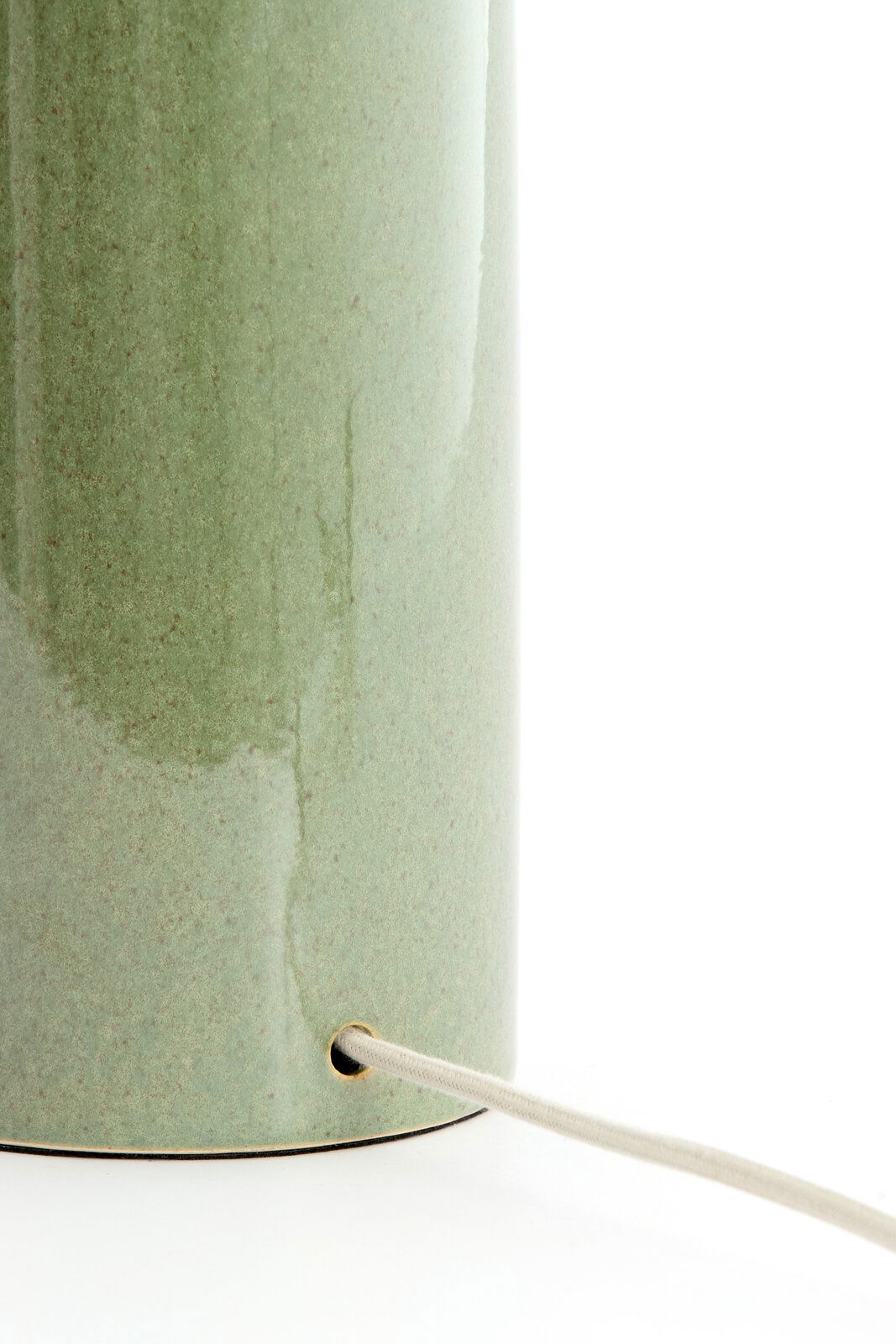 Nahaufnahme eines grünen Lampenfußes mit Kabel, seitliche Perspektive