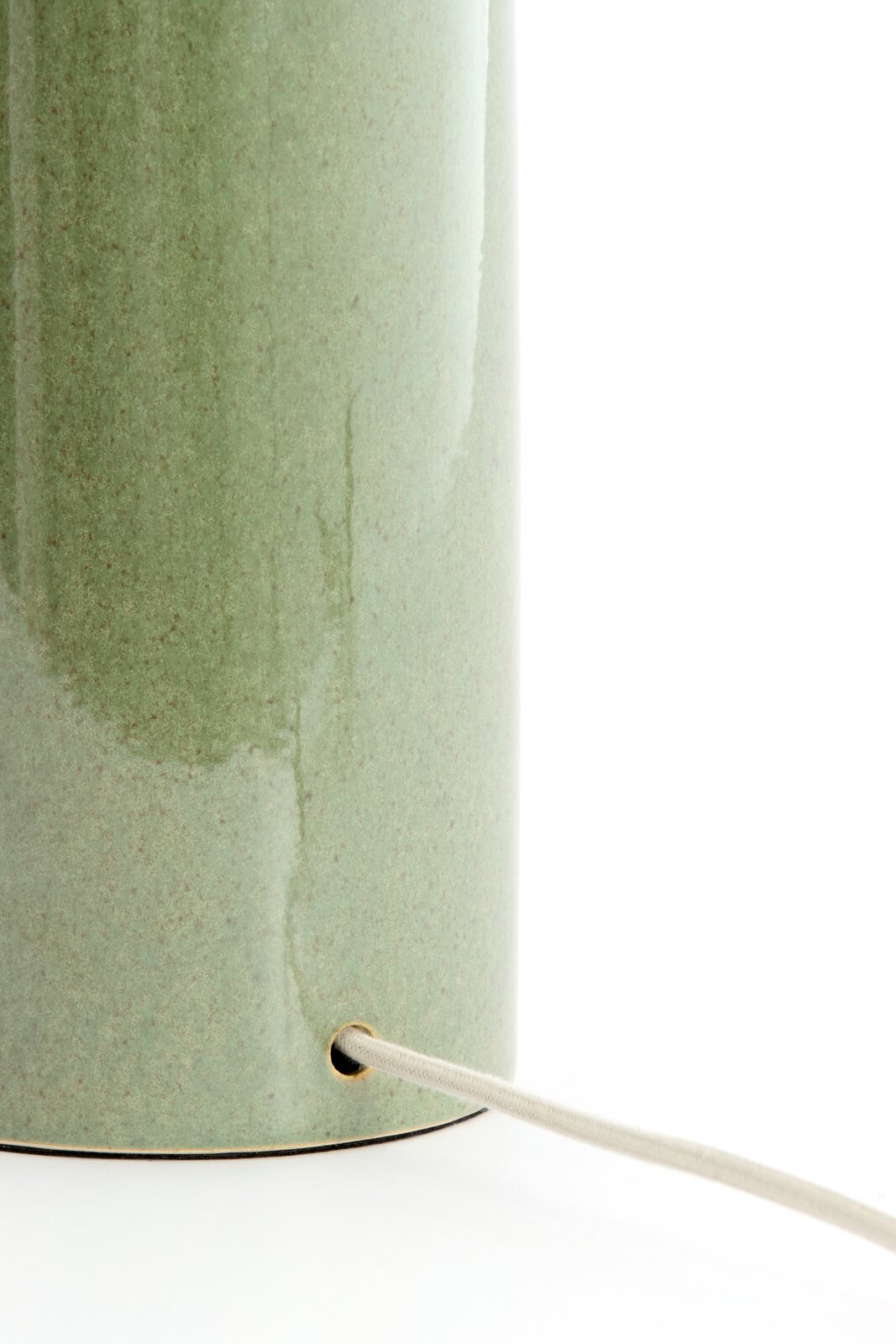 Nahaufnahme eines grünen Lampenfußes mit Kabel, seitliche Perspektive