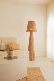 Outdoor-Stehleuchte aus Rattan in einem gemütlichen Wohnzimmer, seitliche Perspektive