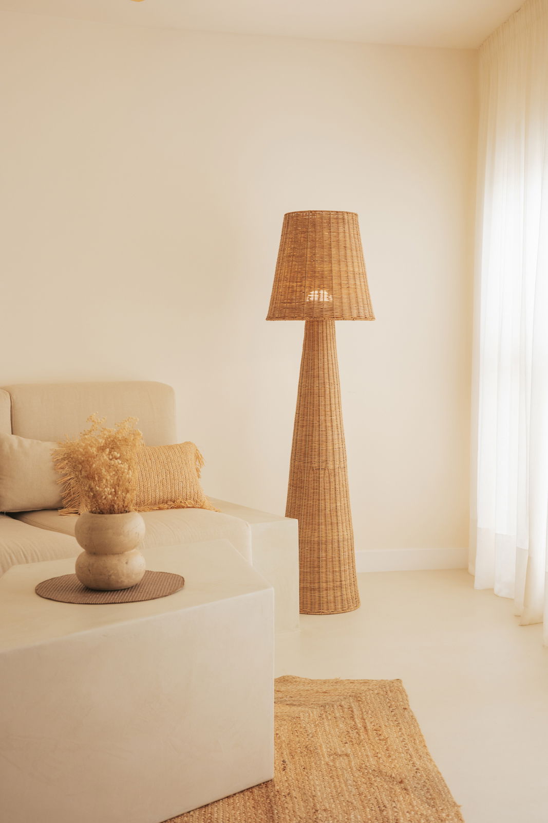 Outdoor-Stehleuchte aus Rattan in einem gemütlichen Wohnzimmer, seitliche Perspektive