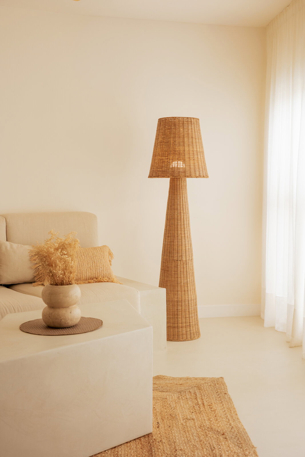 Outdoor-Stehleuchte aus Rattan in einem gemütlichen Wohnzimmer, seitliche Perspektive