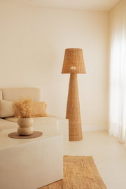 Outdoor-Stehleuchte aus Rattan in einem gemütlichen Wohnzimmer, seitliche Perspektive