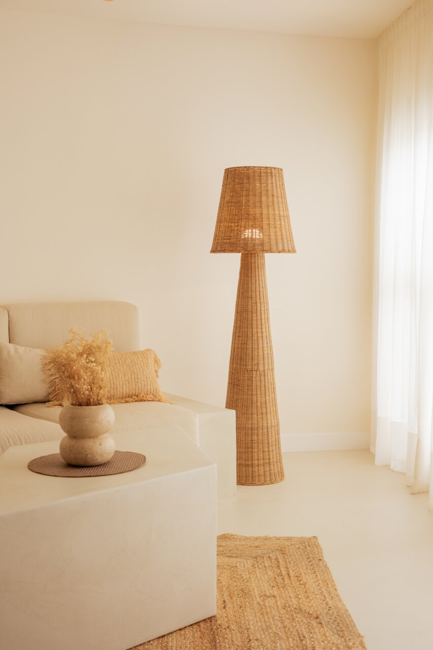 Outdoor-Stehleuchte aus Rattan in einem gemütlichen Wohnzimmer, seitliche Perspektive