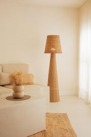 Outdoor-Stehleuchte aus Rattan in einem gemütlichen Wohnzimmer, seitliche Perspektive