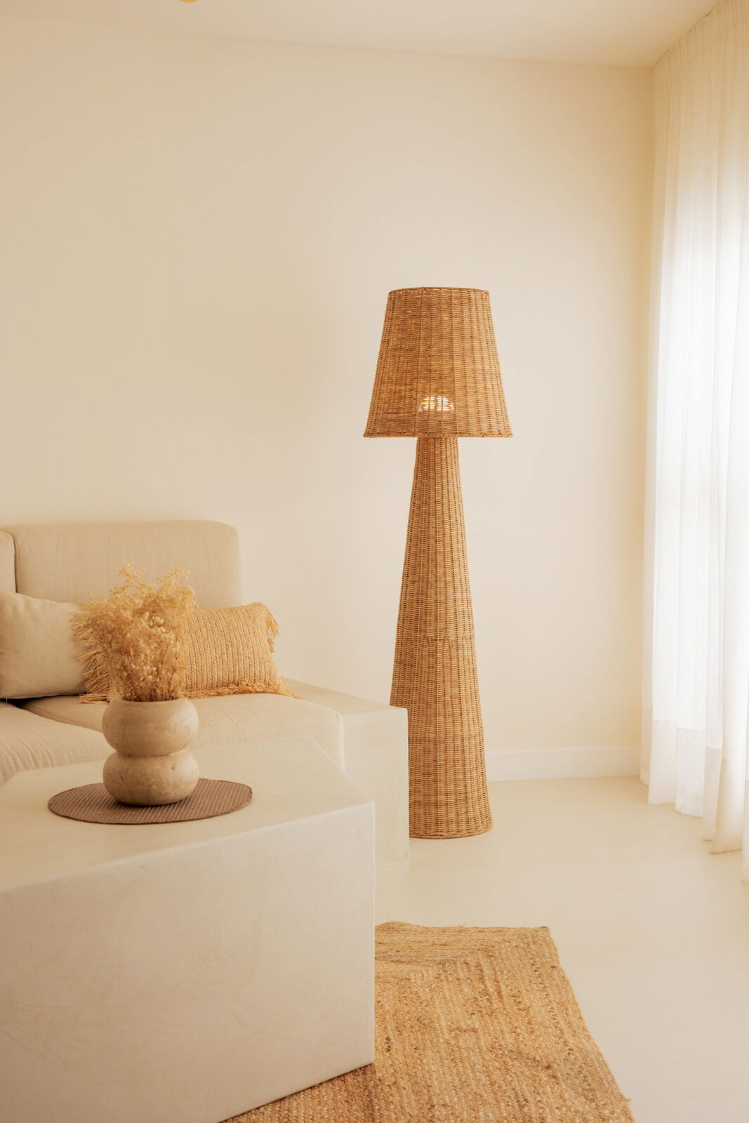 Outdoor-Stehleuchte aus Rattan in einem gemütlichen Wohnzimmer, seitliche Perspektive