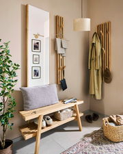 Eingangsbereich mit moderner Garderobe aus Holz, bestehend aus einer Garderobenbank, einem schmalen Garderobenpaneel und einem großen Spiegel. Perspektive von vorne.