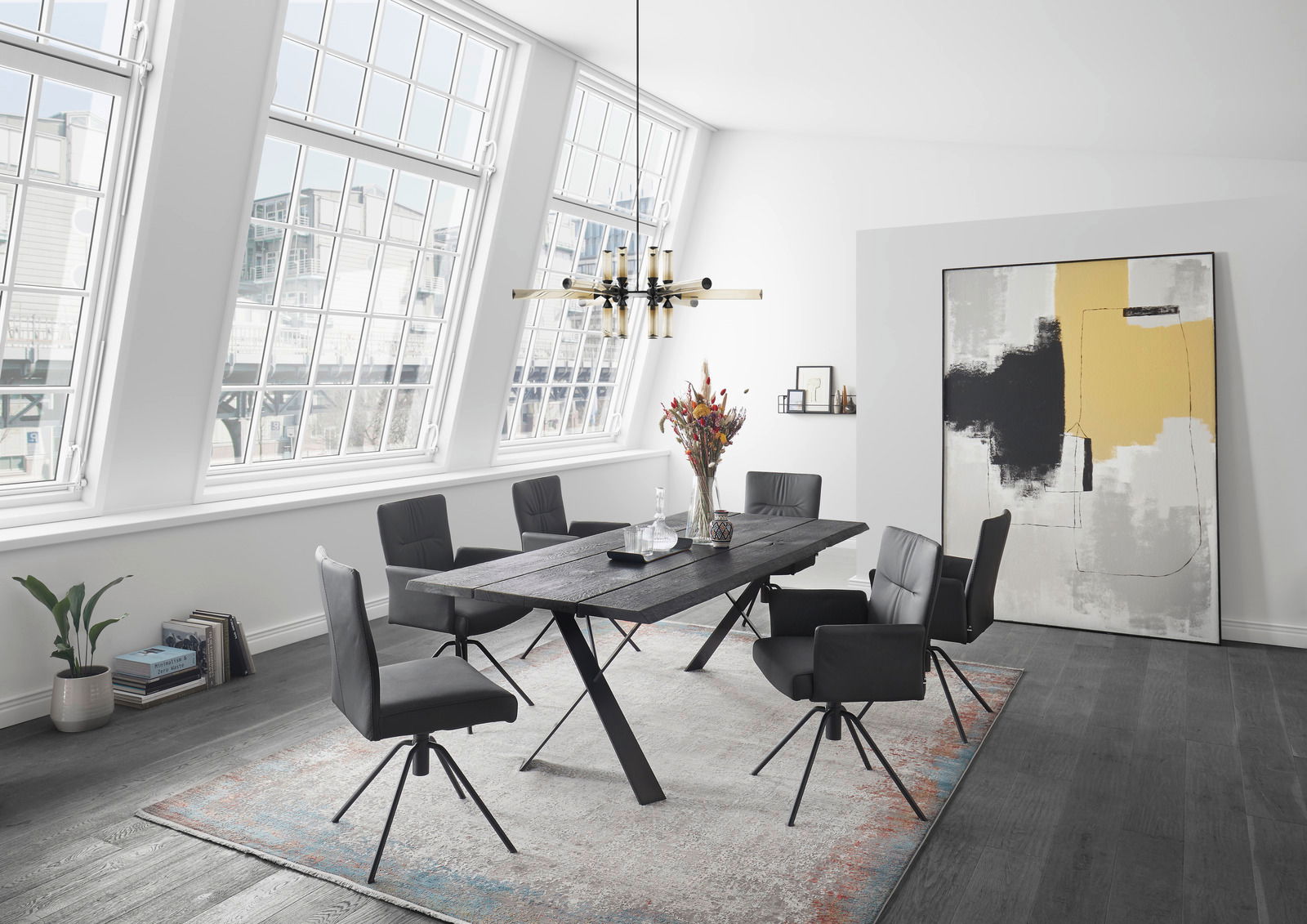 Moderner Essbereich mit sechs schwarzen Sesseln um einen dunklen Holztisch, seitliche Perspektive.