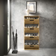 Schuhkipper aus Holz mit vier Klappen, frontal fotografiert, gefüllt mit verschiedenen Schuhen, steht in einem modernen Raum neben einem Schirmständer.