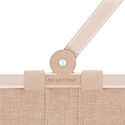 Close-up van het bovenste gedeelte van een beige carrybag XS van reisenthel, met zichtbaar handvatgewricht en merklogo.