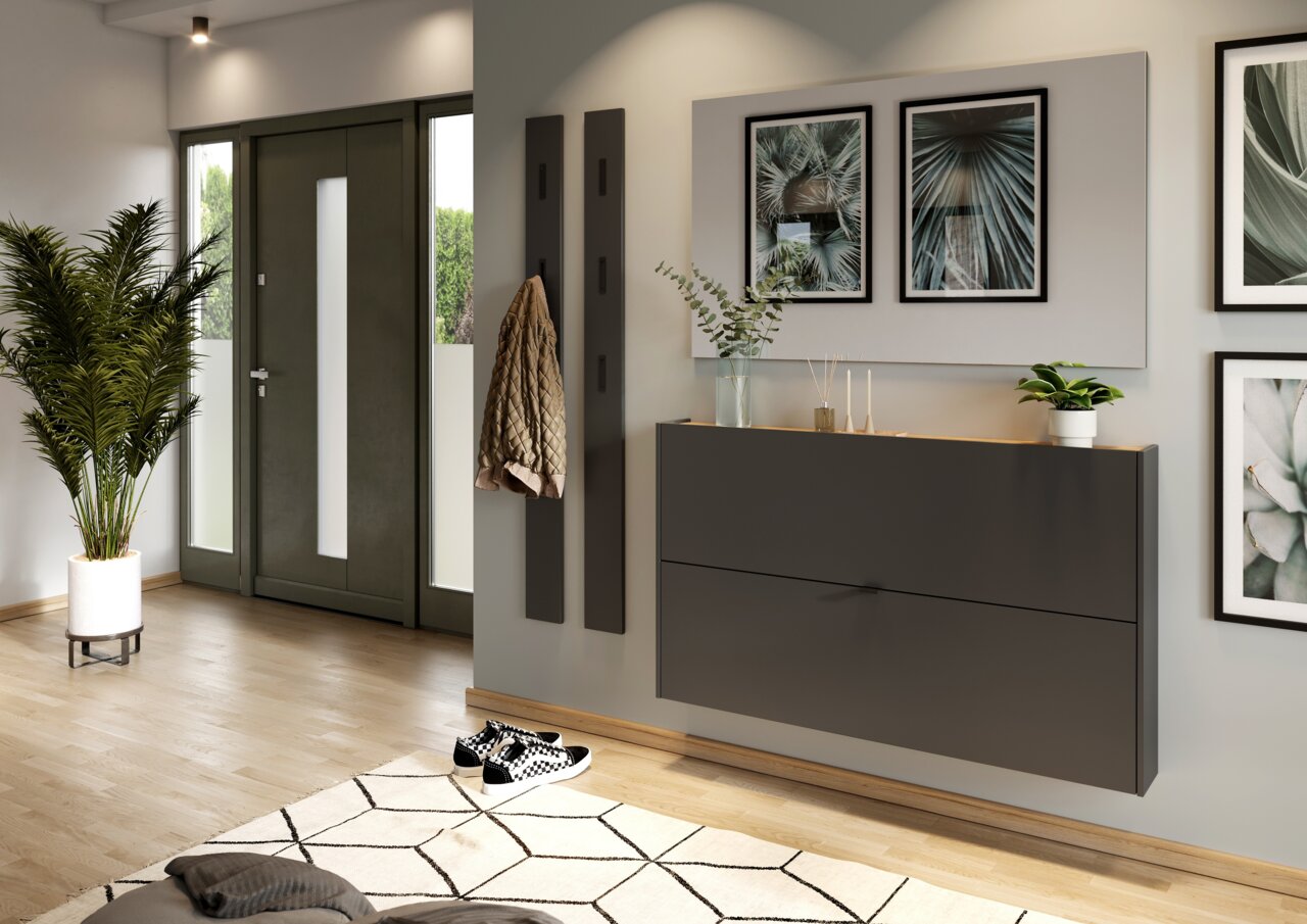 Moderner Schuhschrank in dunklem Design, an der Wand montiert, mit Pflanzen und Dekorationen darauf, aus seitlicher Perspektive fotografiert.