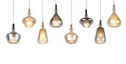 Mehrere moderne Pendelleuchten mit mundgeblasenen Glasschirmen in Rauch- und Bernsteintönen, eingeschaltet vor weißem Hintergrund, Frontalansicht