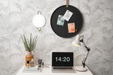 Rundes schwarzes Memoboard an der Wand mit drei befestigten Karten, umgeben von einem dekorativen Spiegel, einer Tischlampe und einem Laptop auf einem Schreibtisch. Perspektive: Frontalansicht.