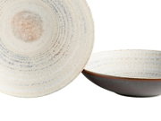Zwei runde Keramikschalen/Servierschalen mit cremefarbener, gesprenkelter Glasur und konzentrischen Rillen, außen dunkelbraun, freigestellt auf Weiß; Perspektive: eine Schale frontal von oben, die zweite seitlich in leicht schräger Ansicht