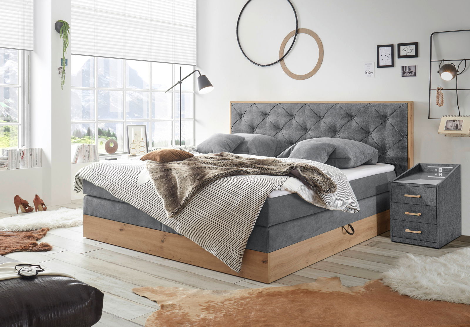 Gemütliches Schlafzimmer mit Boxspringbett und Nachtkonsole in moderner Einrichtung, seitliche Perspektive