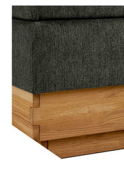 Nahaufnahme eines Boxspringbettes mit grauem Stoffbezug und Holzrahmen, Perspektive von der Ecke.
