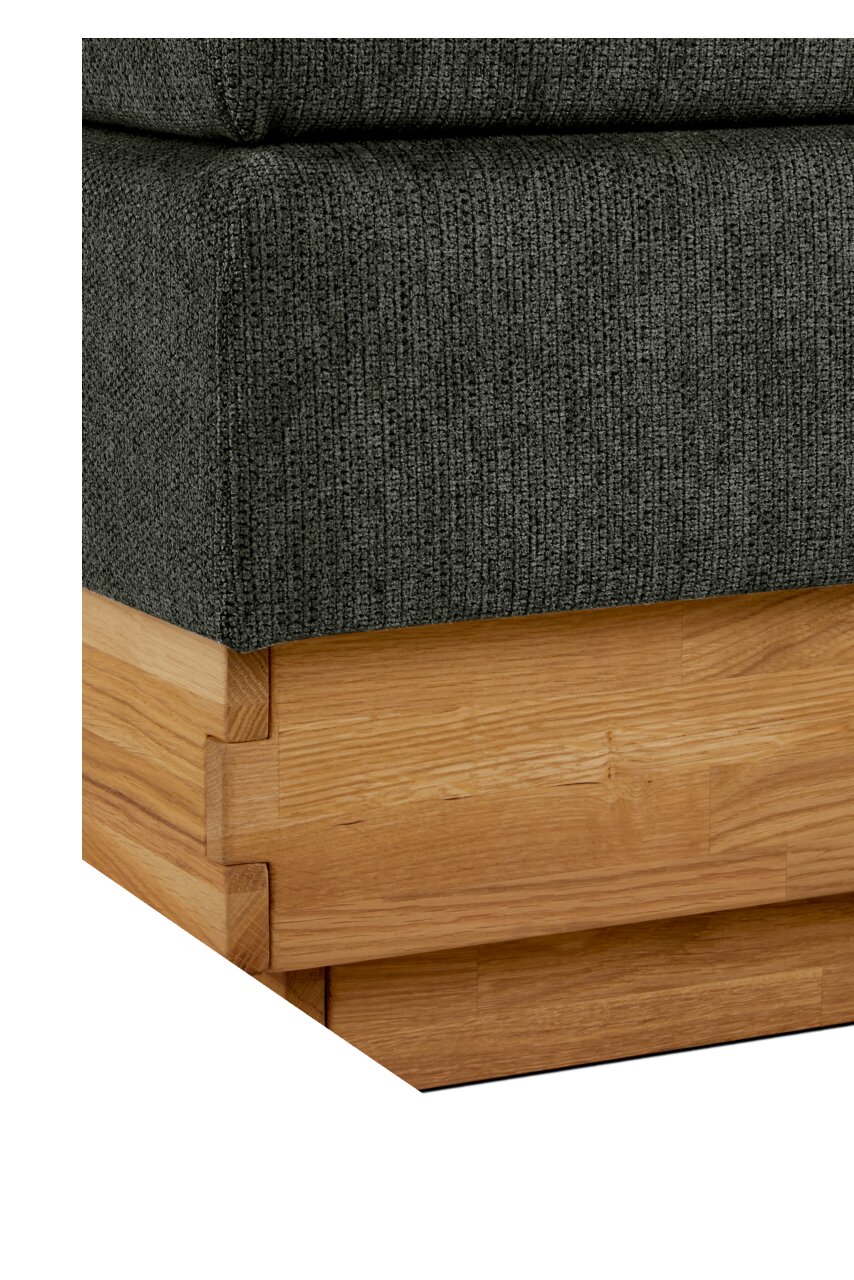 Nahaufnahme eines Boxspringbettes mit grauem Stoffbezug und Holzrahmen, Perspektive von der Ecke.