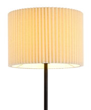 Nahaufnahme einer Stehleuchte mit einem geriffelten, cremefarbenen Lampenschirm und einem schwarzen Ständer.