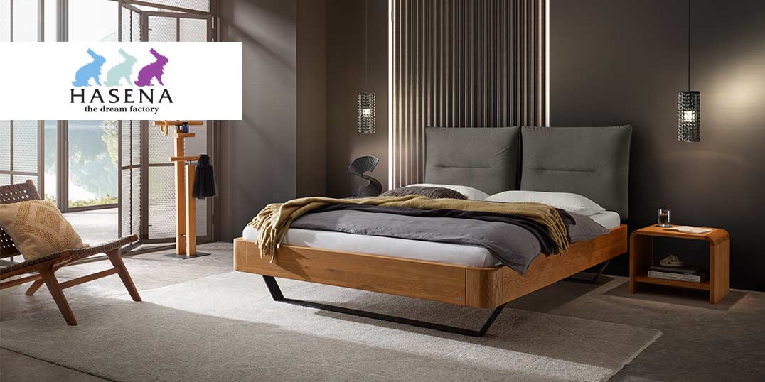 Elegantes Schlafzimmer mit einem Holzbett mit grauem Polsterkopfteil, kuscheliger Decke und stilvoller Beleuchtung.